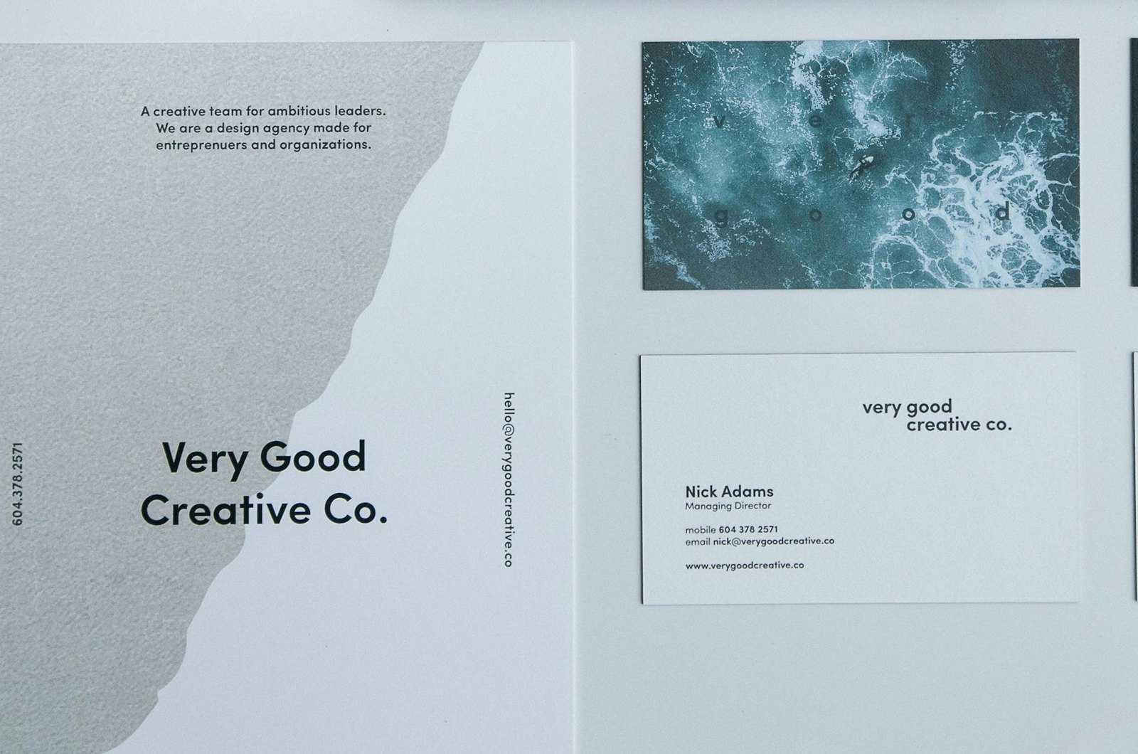 Printed brochure and business cards laid out on a white desk