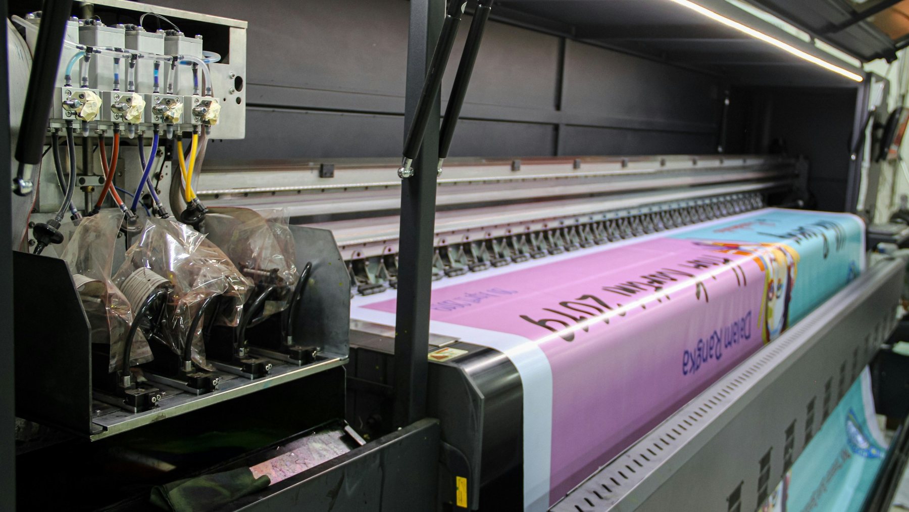 Large-format printer producing a banner in a print workshop
